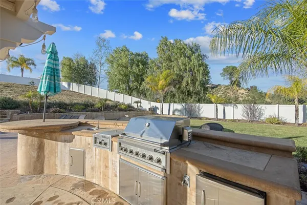 a view of a patio with couches and table and chairs with wooden fence