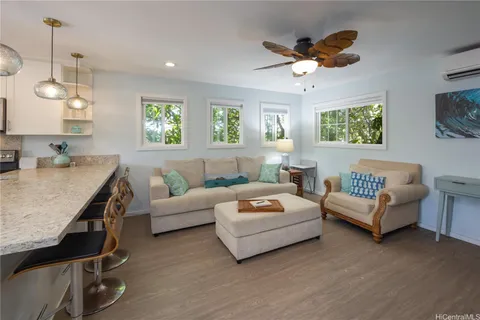 a living room with furniture ceiling fan and a window