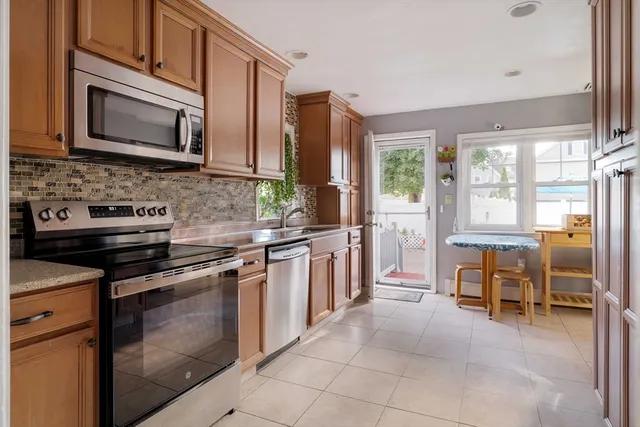 a kitchen with stainless steel appliances granite countertop a stove microwave and sink