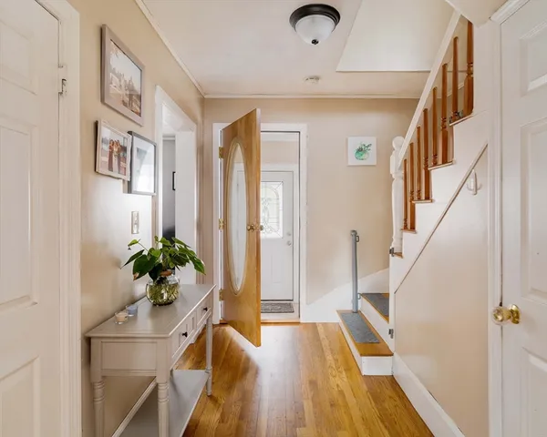 a view of a hallway to a house with wooden floor and stairs