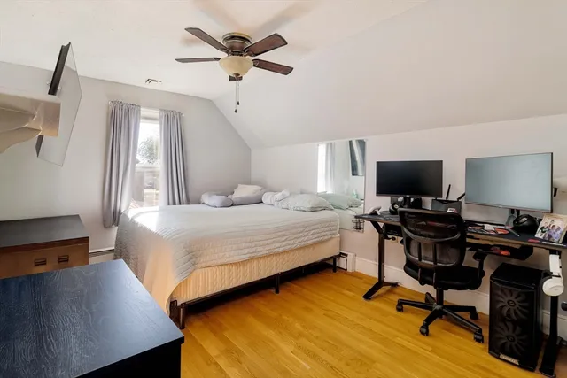 a bedroom with a bed window and a flat screen tv