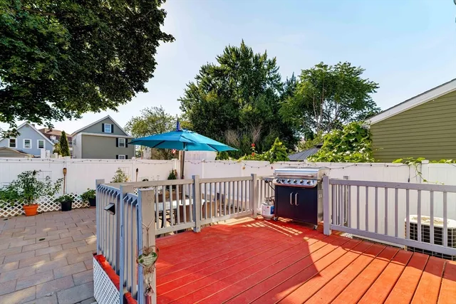 a view of a deck with a table and chairs a barbeque with wooden floor and fence