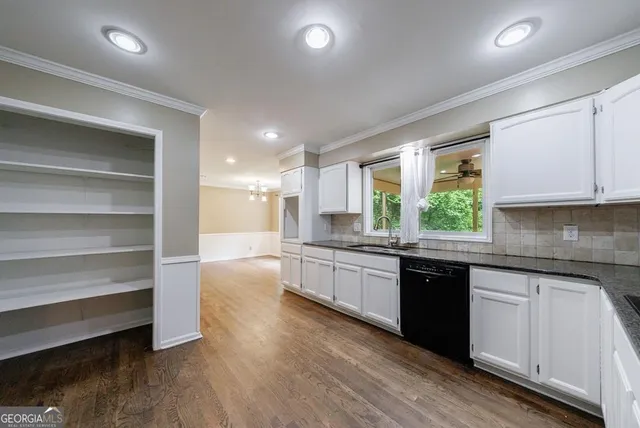 an empty room with wooden floor and window