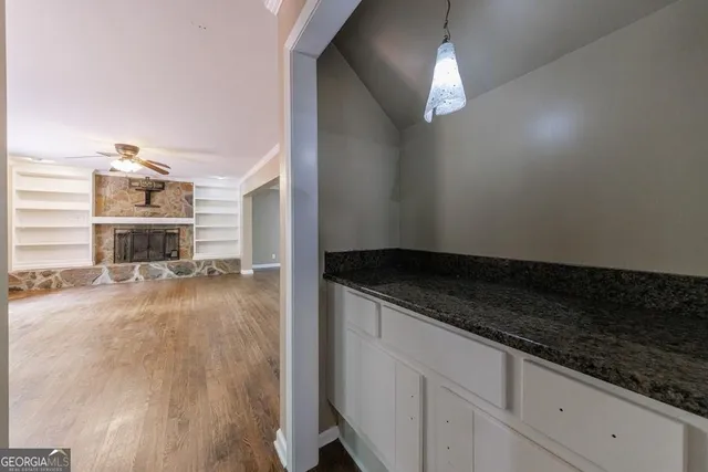 a view of an empty room with a fireplace and a window