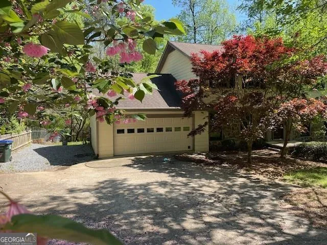 a front view of a house with a yard and a tree