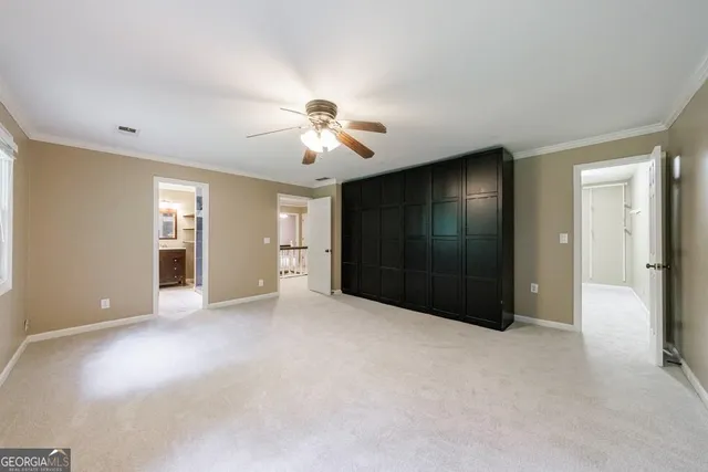 a view of an empty room with chandelier fan