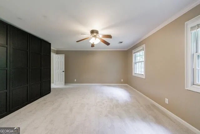 an empty room with a window and a fan