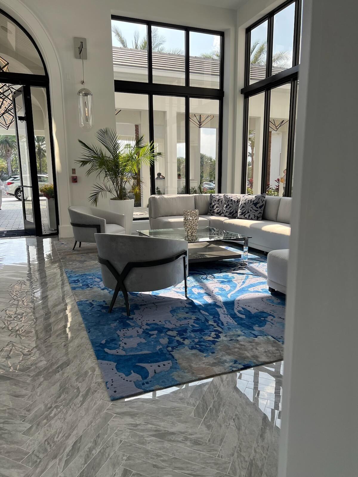 6675 Northwest 25th Way Boca Raton, FL 33496 - Photo 34 of 54 a living room with large windows and a table