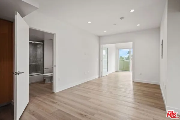 an empty room with wooden floor and sliding door