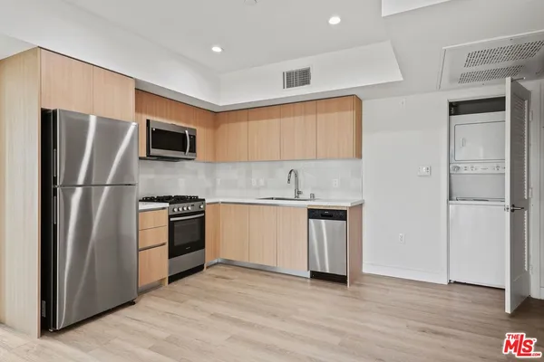 a kitchen with stainless steel appliances granite countertop a refrigerator and a stove top oven