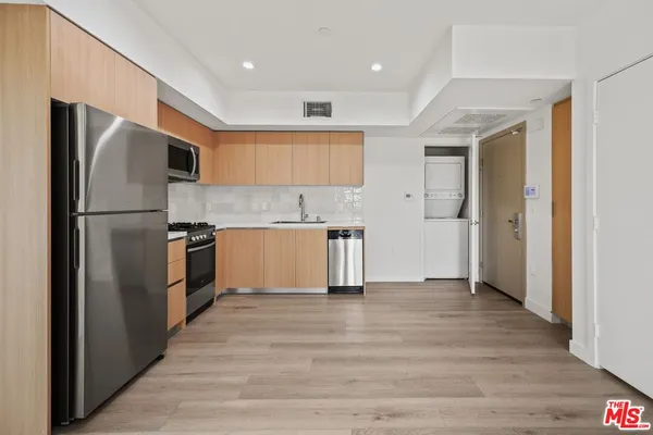 a kitchen with stainless steel appliances a refrigerator and a stove top oven