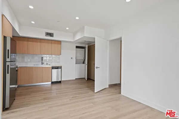 a view of a kitchen with a sink and a refrigerator