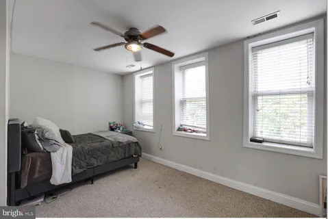 a bed room with a bed and a ceiling fan