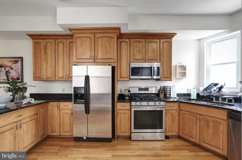 a kitchen with a refrigerator stove top oven and sink