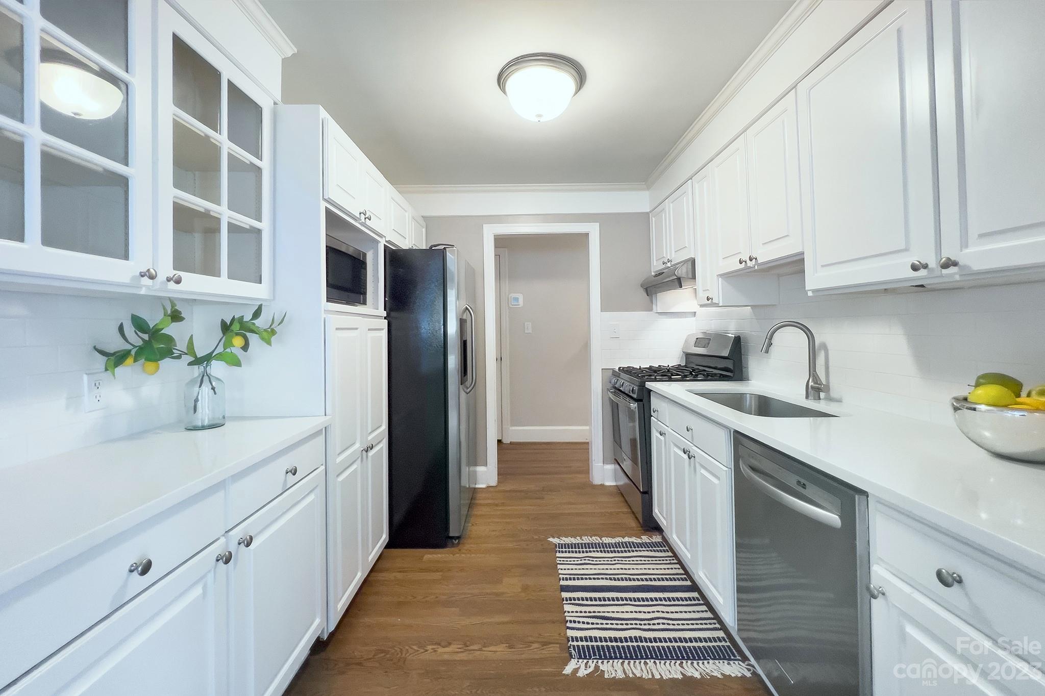 1000 Sedgefield Road Charlotte, NC 28209 - Photo 12 of 29 a kitchen with stainless steel appliances a sink stove and cabinets