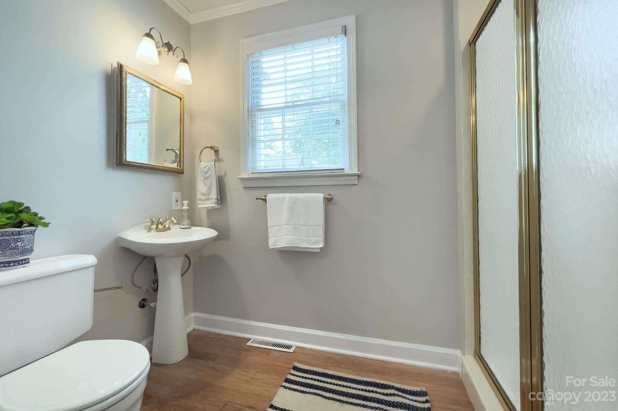 1000 Sedgefield Road Charlotte, NC 28209 - Photo 22 of 29 a bathroom with a sink a mirror a toilet and a window