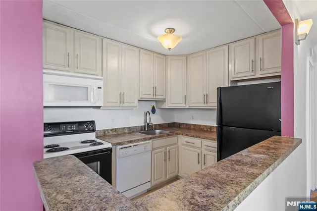 a kitchen with granite countertop a refrigerator and a sink