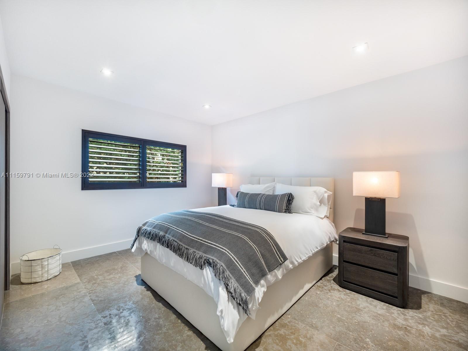 1540 Cleveland Road Miami Beach, FL 33141 - Photo 17 of 28 a spacious bedroom with a bed and a lamp