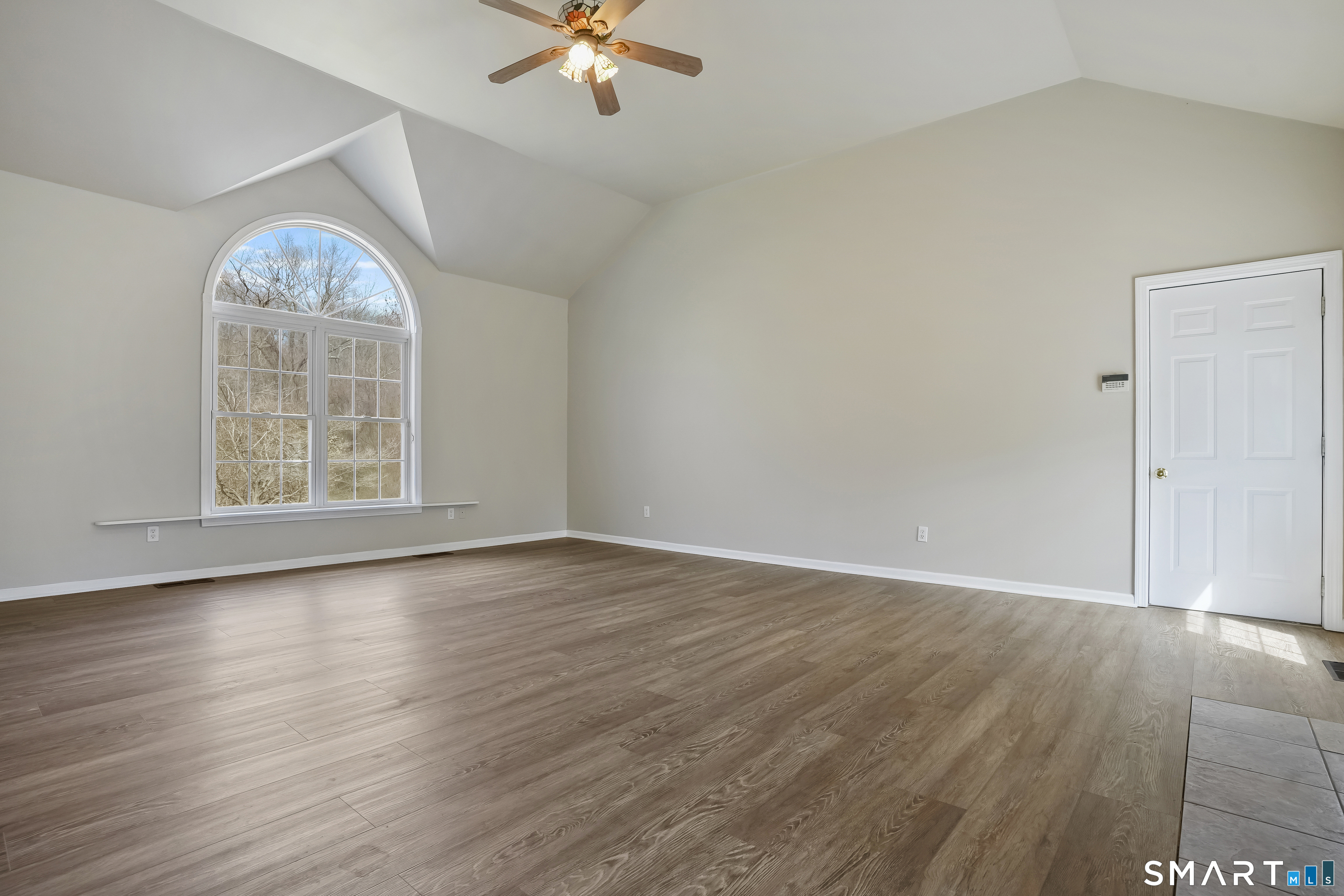 72 Perry Hill Road Shelton, CT 06484 - Photo 10 of 36 an empty room with wooden floor chandelier fan and windows