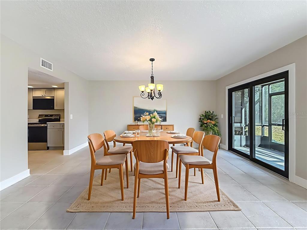 11603 West Bayshore Drive, Unit 118 Crystal River, FL 34429 - Photo 18 of 73 a dining room with furniture a chandelier and wooden floor