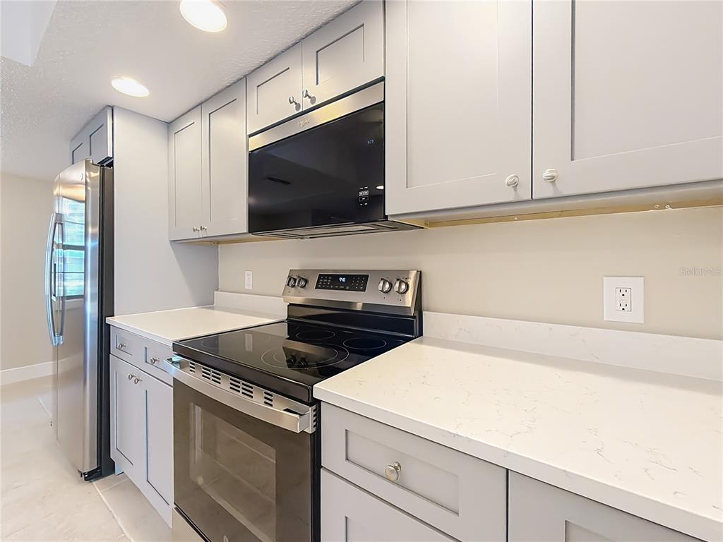 11603 West Bayshore Drive, Unit 118 Crystal River, FL 34429 - Photo 21 of 73 a kitchen with a stove and a microwave