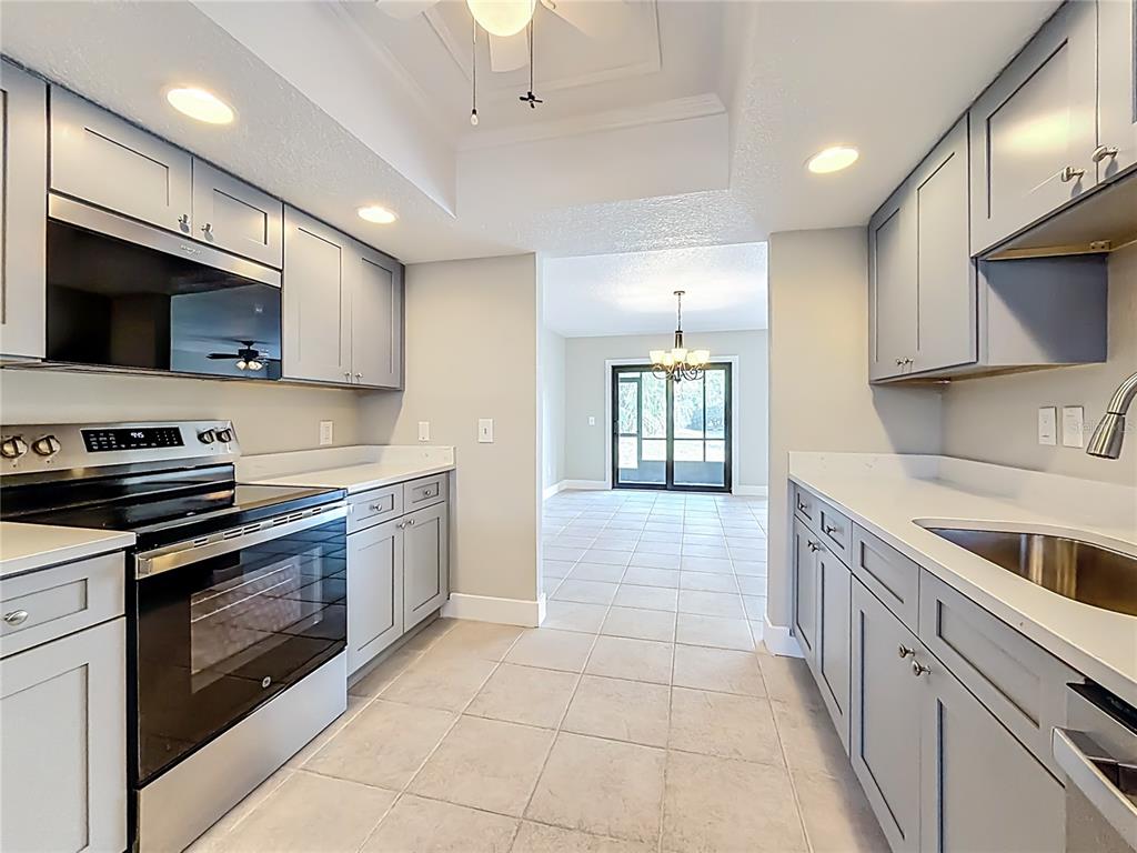 11603 West Bayshore Drive, Unit 118 Crystal River, FL 34429 - Photo 24 of 73 a kitchen with stainless steel appliances granite countertop a stove a sink and a microwave