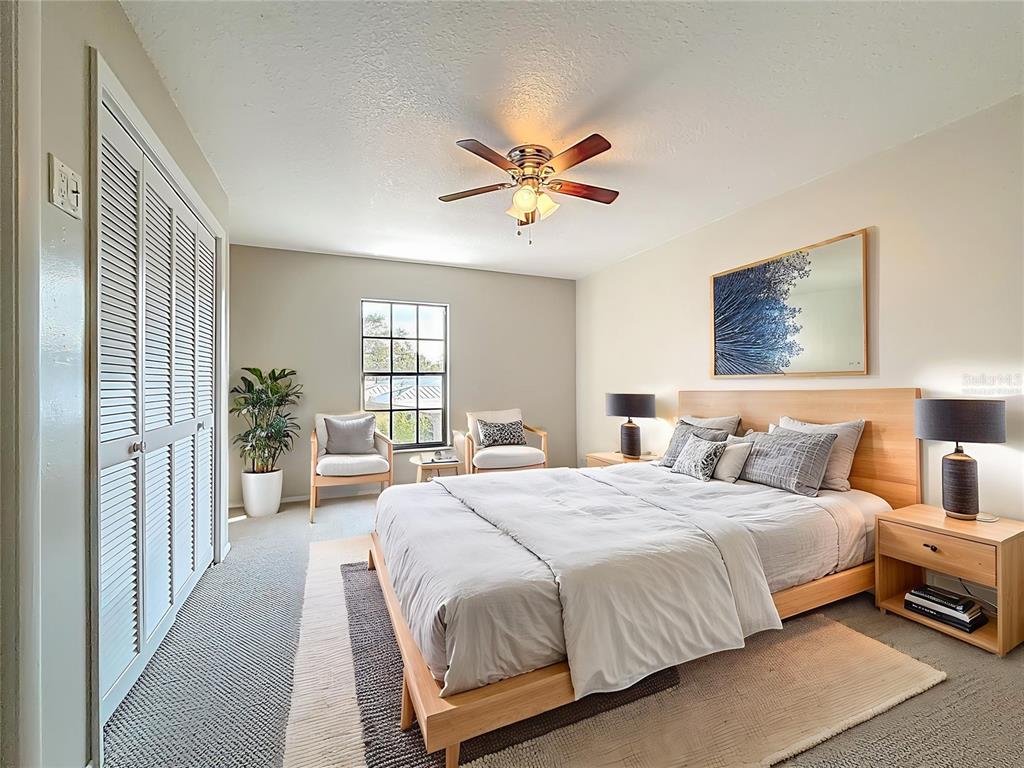 11603 West Bayshore Drive, Unit 118 Crystal River, FL 34429 - Photo 37 of 73 a bedroom with a balcony a bed and a chandelier