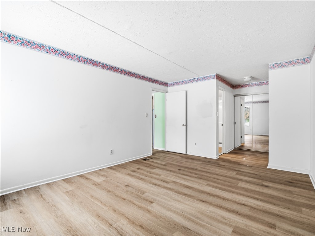 22968 Maple Ridge Road, Unit 103 North Olmsted, OH 44070 - Photo 14 of 25 Unfurnished room with light wood-style floors and a textured ceiling