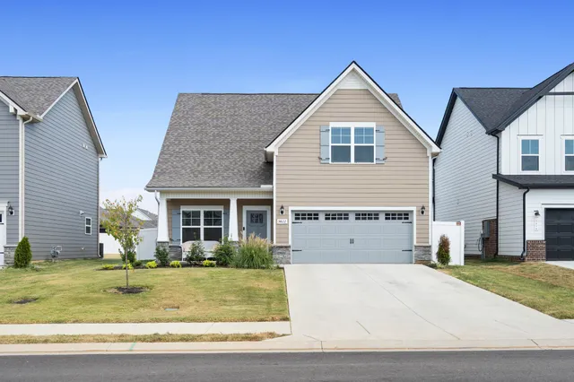 a view of a house with small yard plants and palm trees