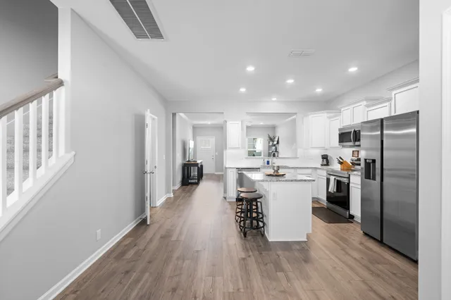 a kitchen with a refrigerator and white cabinets