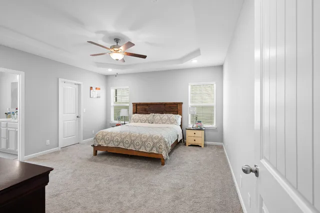 a spacious bedroom with a bed and a chandelier