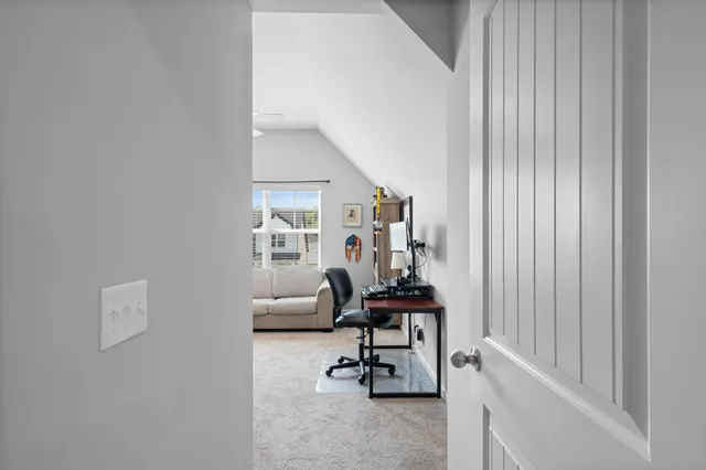 a view of a workspace with furniture and a window