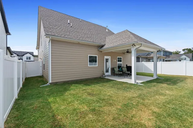a view of a house with backyard and a tree