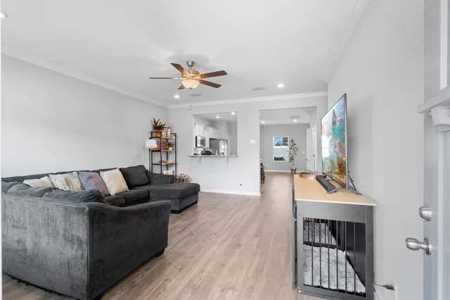 a living room with furniture and a wooden floor