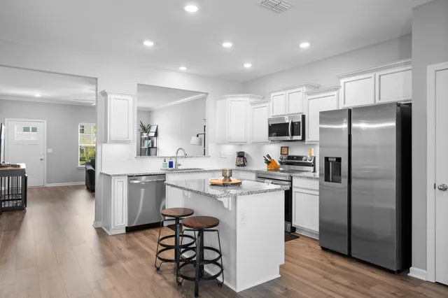 a kitchen with refrigerator and chairs