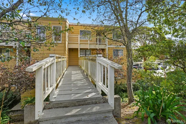 a view of a brick house with wooden floor and fence