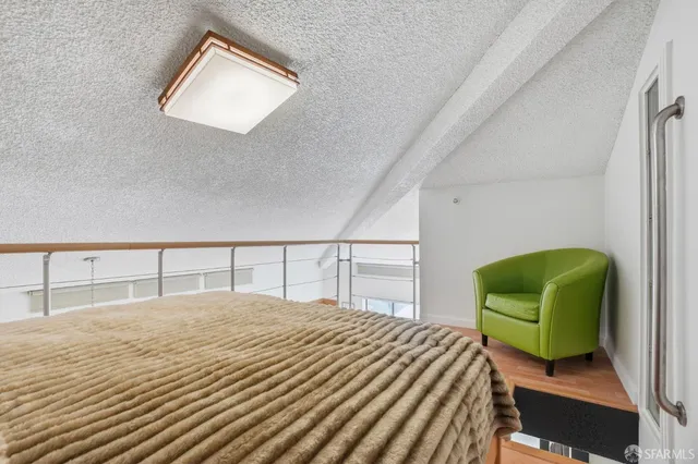 a bedroom with a bed and painting on the wall