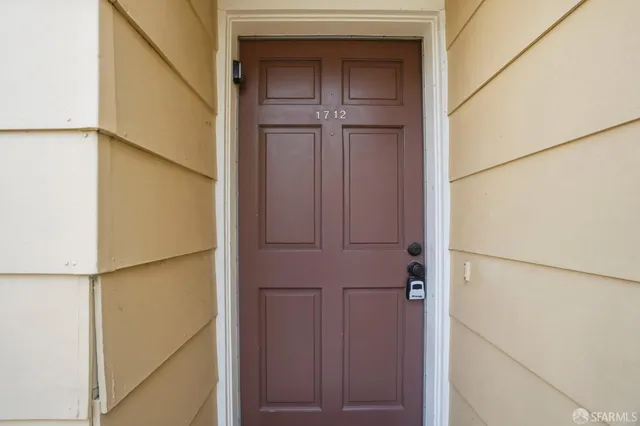 a view of a hallway with wooden floor and a bathroom