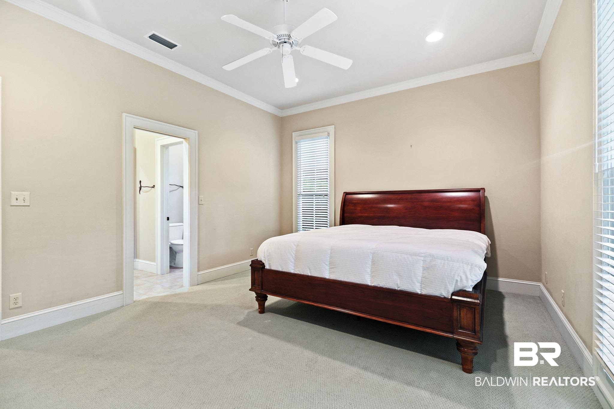 202 Beall Lane Daphne, AL 36526 - Photo 27 of 46 Carpeted bedroom featuring ensuite bathroom, crown molding, and ceiling fan