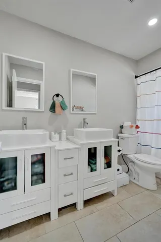 a bathroom with a double vanity sink a mirror and bathtub