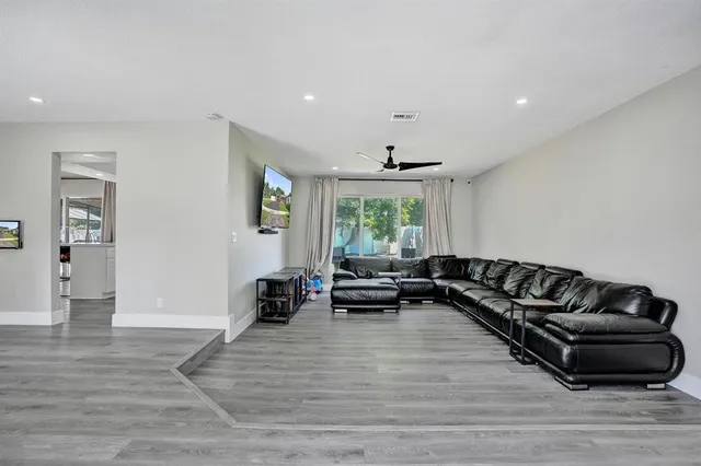 a living room with furniture and a wooden floor