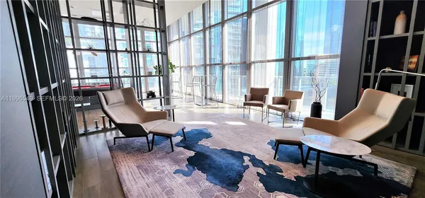 a living room with furniture and a floor to ceiling window