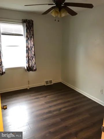 a view of a room with wooden floor and window