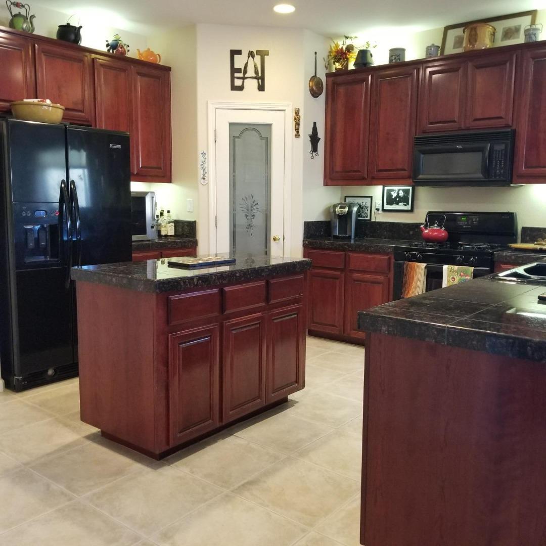 20640 Sarazen Place Patterson, CA 95363 - Photo 2 of 7 a kitchen with stainless steel appliances granite countertop a stove a refrigerator and a sink with wooden cabinets