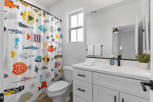 a bathroom with a sink a toilet and shower curtain
