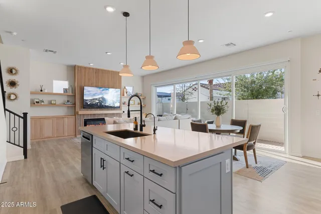 a kitchen with granite countertop a sink a counter top space and living room view