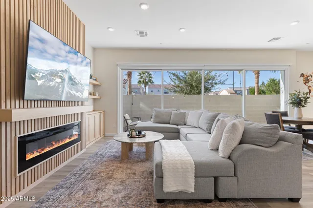 a living room with furniture a fireplace and a large window