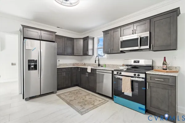 a kitchen with stainless steel appliances granite countertop a sink stove and refrigerator