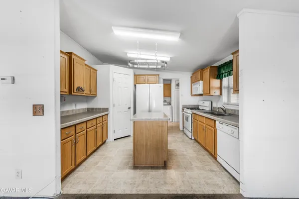 a large kitchen with stainless steel appliances granite countertop a stove a sink dishwasher and a refrigerator