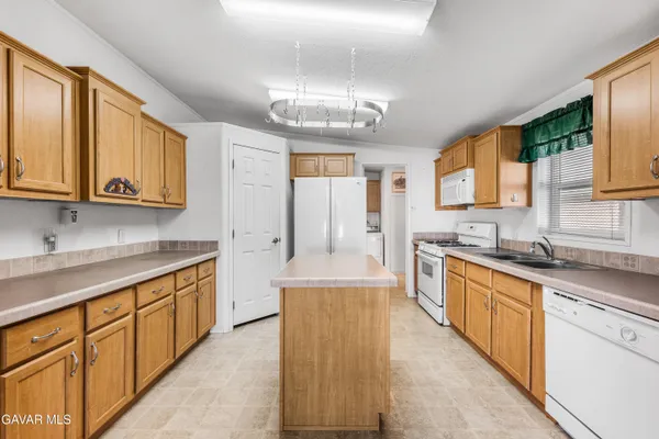 a large kitchen with stainless steel appliances granite countertop a sink and cabinets